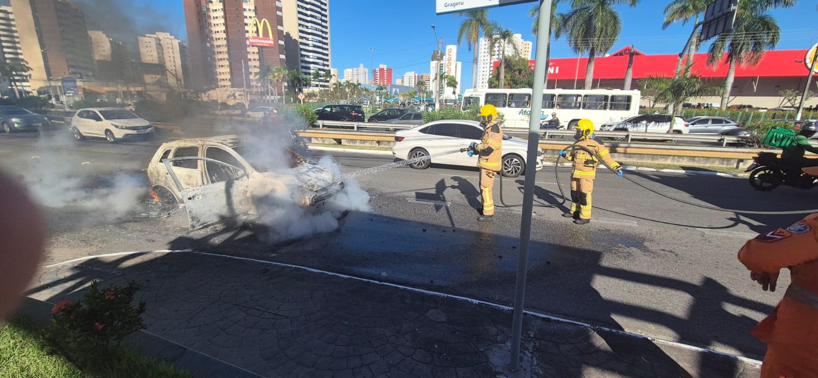 Carro pega fogo em frente ao Shopping Jardins; bombeiros controlam as chamas