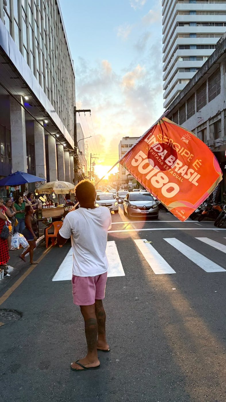 Apoiador ergue bandeira da campanha no fim da tarde, no Centro de Aracaju